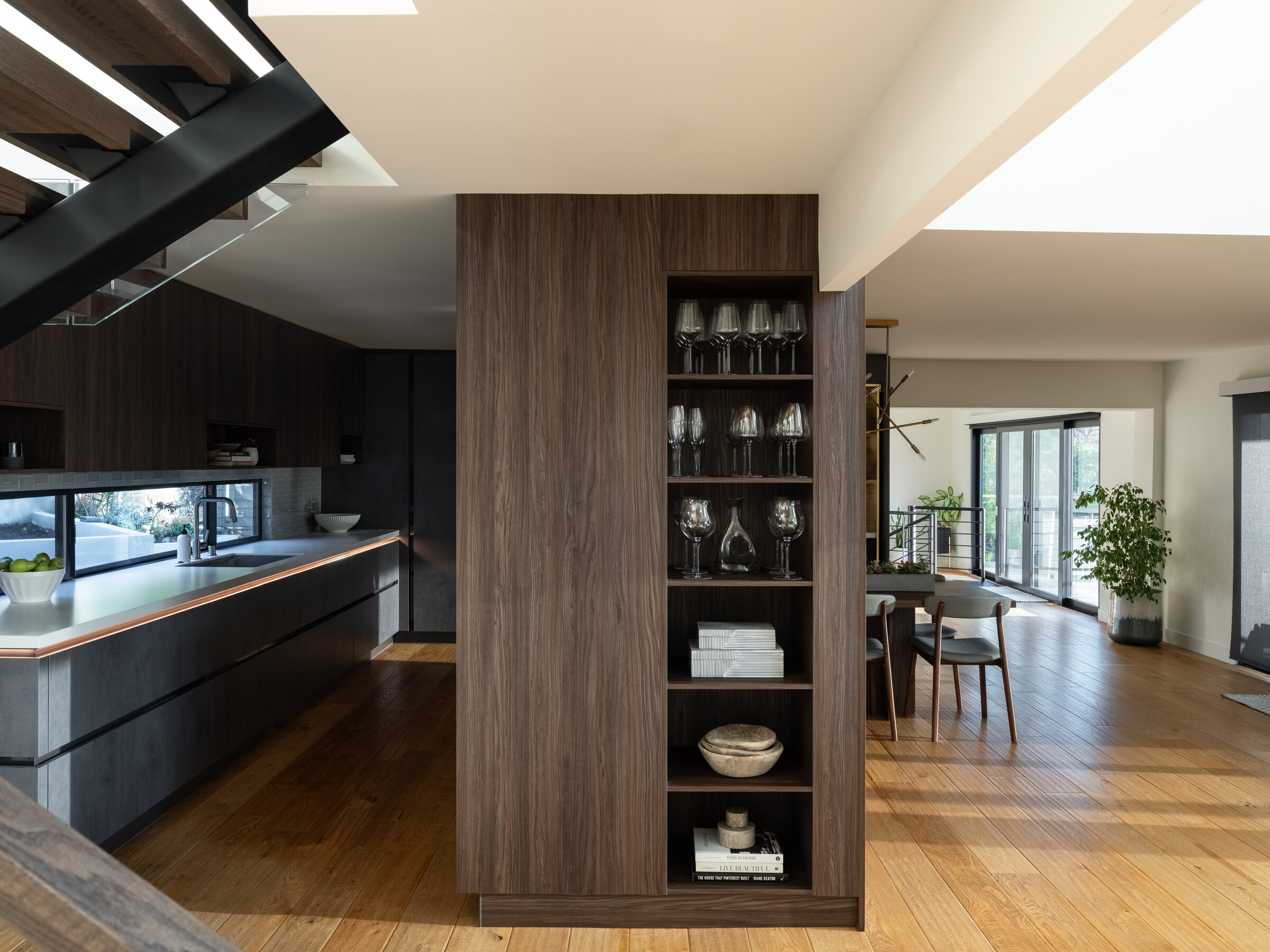 Completed open kitchen and living renovation showing coordinated layout, cabinetry, lighting, and circulation