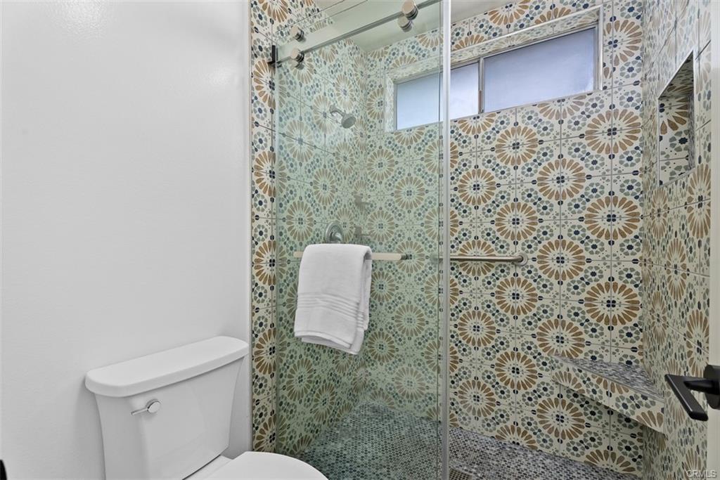 Completed modern walk-in shower remodel with coordinated tile, waterproofing, plumbing, glass, and lighting