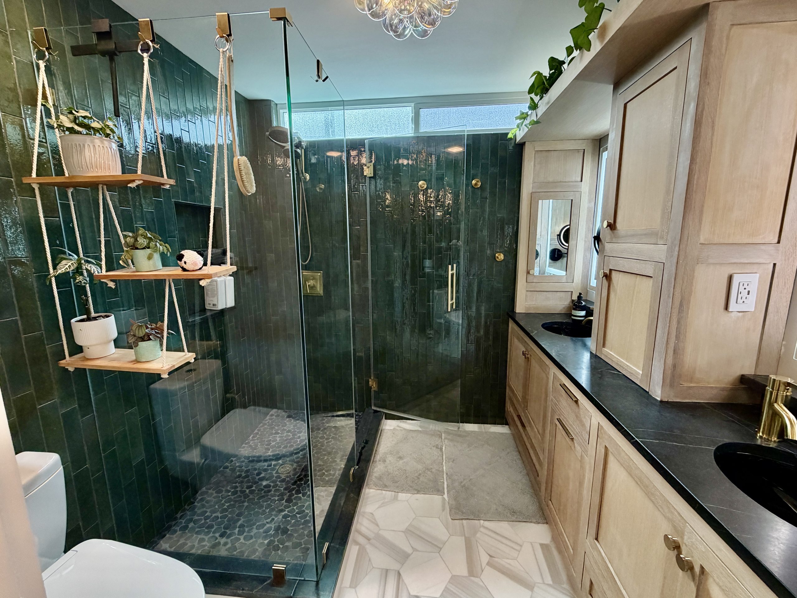Emerald green walk-in shower with glass enclosure and custom wood vanity